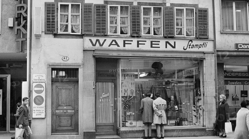 Arms shop; men watching in the shop window 1969.