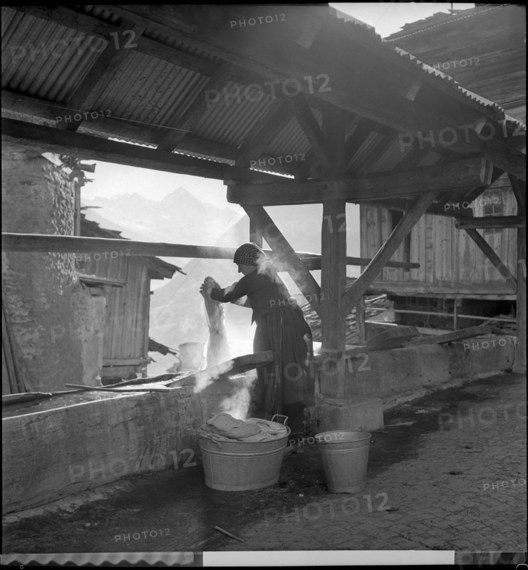 Woman doing the washing in village in Valais.