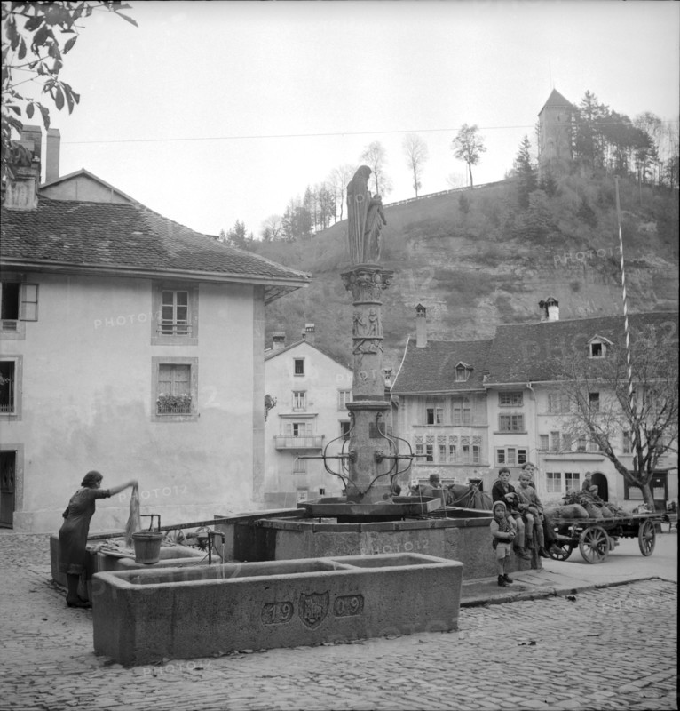 Fribourg; laundress at St. Anne fountain; 1945.