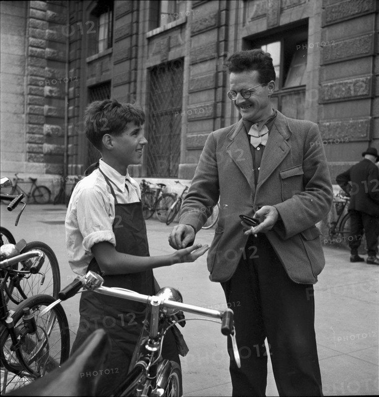 Basle, client paying for the cleaning of his bicycle; 1941.