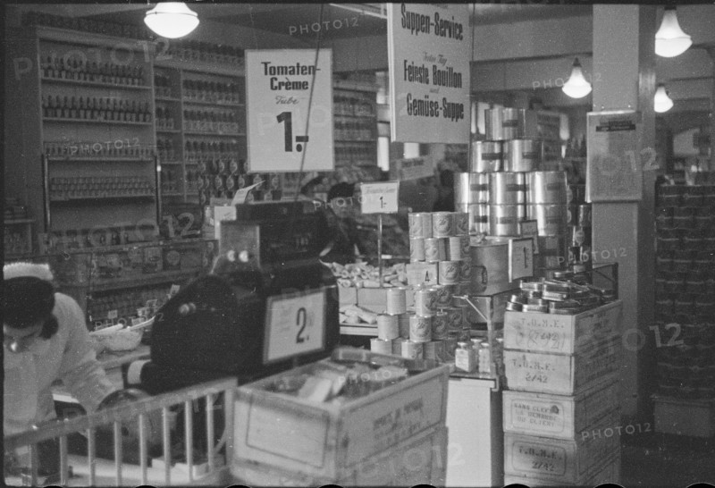 Salesperson in a food shop; soup on offer; 1945.