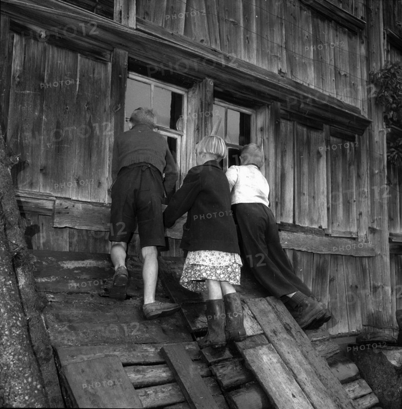 Auction in  Appenzell: nosy children peering through window; 1955.