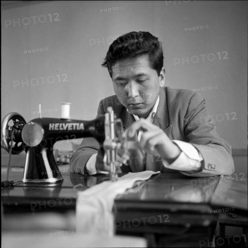 Tibetan refugee learning to sew at sewing machine, Waldstatt 1962.