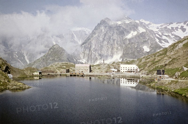 Hospice du Grand Saint Bernard, Pennine Alps, Monastery buildings, Saint Bernard Pass, Valais, Switzerland, July 1959 Alpine peaks and lake Lac du Grand.