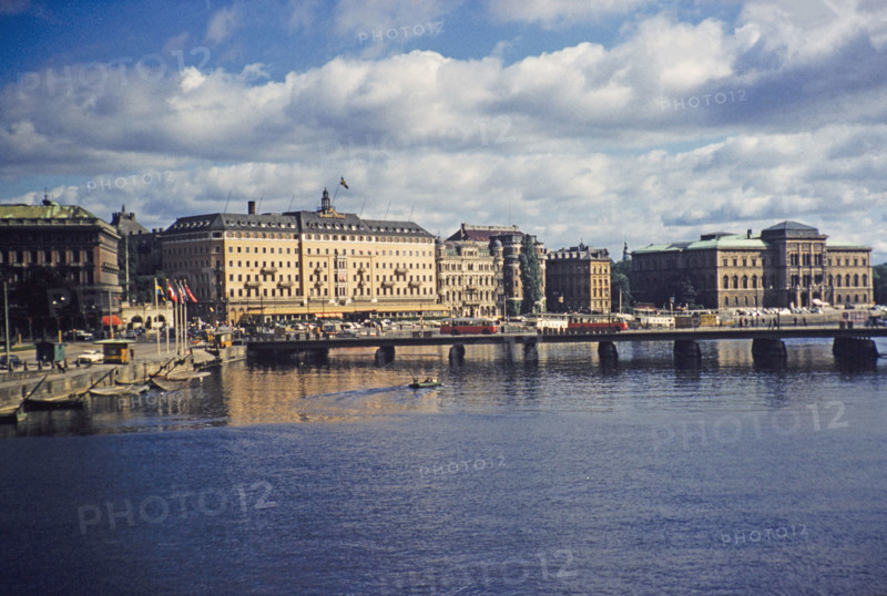 Buses crossing Strombron bridge in city centre with Grand Hotel and National Museum buildings behind, Stockholm, Sweden 1958.