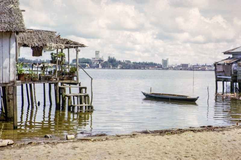 View across Straits from coastal village Kampong Lorong Fatimah in Singapore to Johor Bahru, Malaysia, Southeast Asia c 1964.