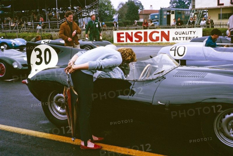 Whitsun Sports car race 3 June 1963, John Coundley in Jaguar D-type car on start line, Goodwood, England, UK, his wife Pat leaning over.