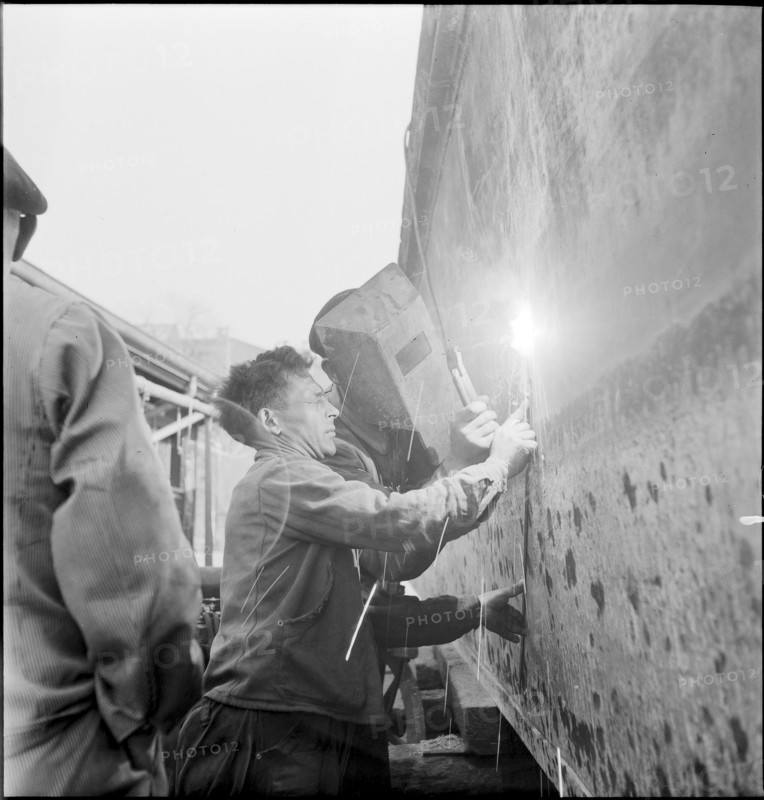 Preparation of overland ship transpor, cutting hull in two with blowtorch, 1946