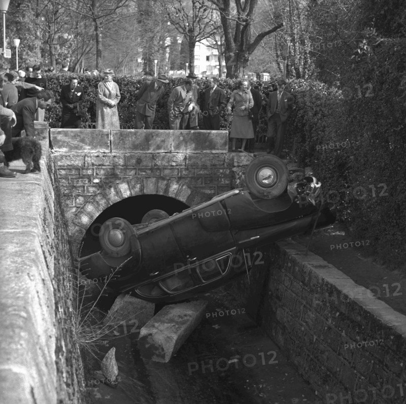 Onlookers watching car recovery out of a stream in Lausanne 1955