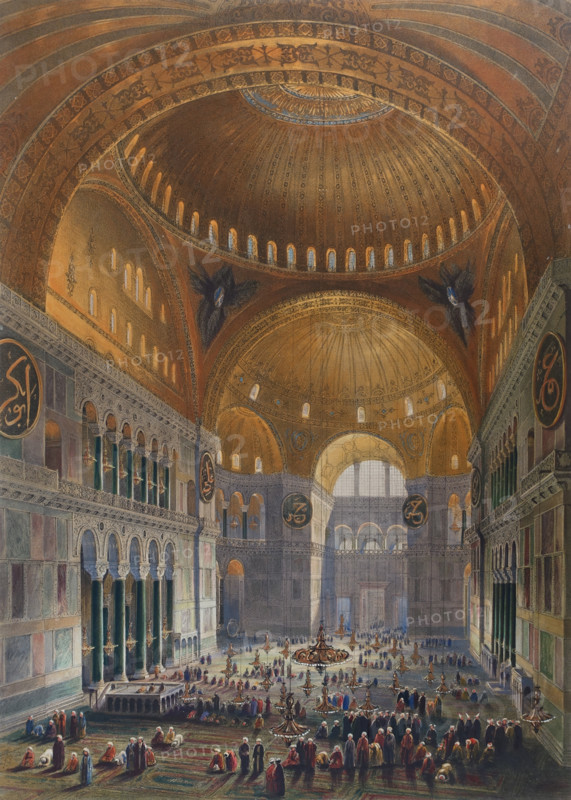 General view of the large nave, facing east of Ayasofya Mosque with groups of men in traditional dress.