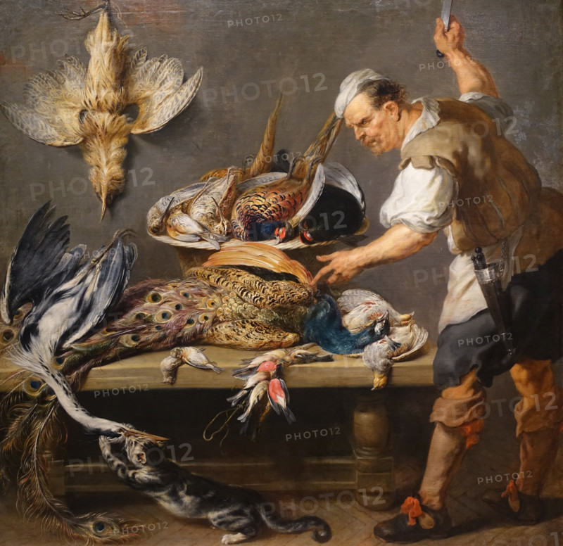 Cook at a table with wildfowl.