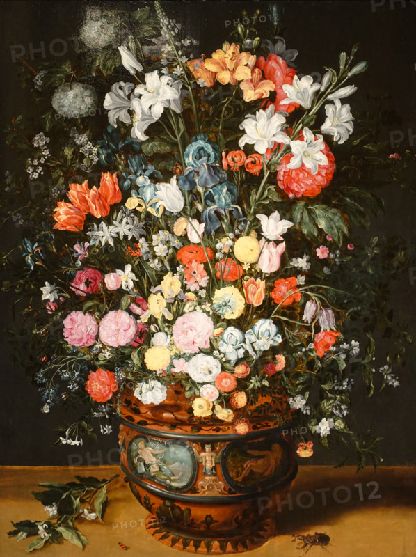A large bouquet of lilies, irises, tulips, orchids and peonies in a vase decorated with images of Amphitrite and Ceres.
