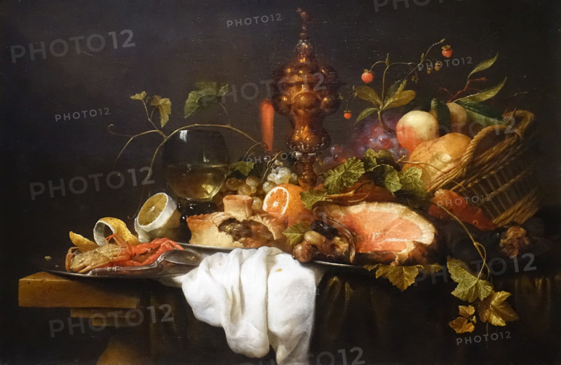 Still life with a basket of fruit, a gilded goblet, a rumer glass, ham, pie, crab and lemon on a table.