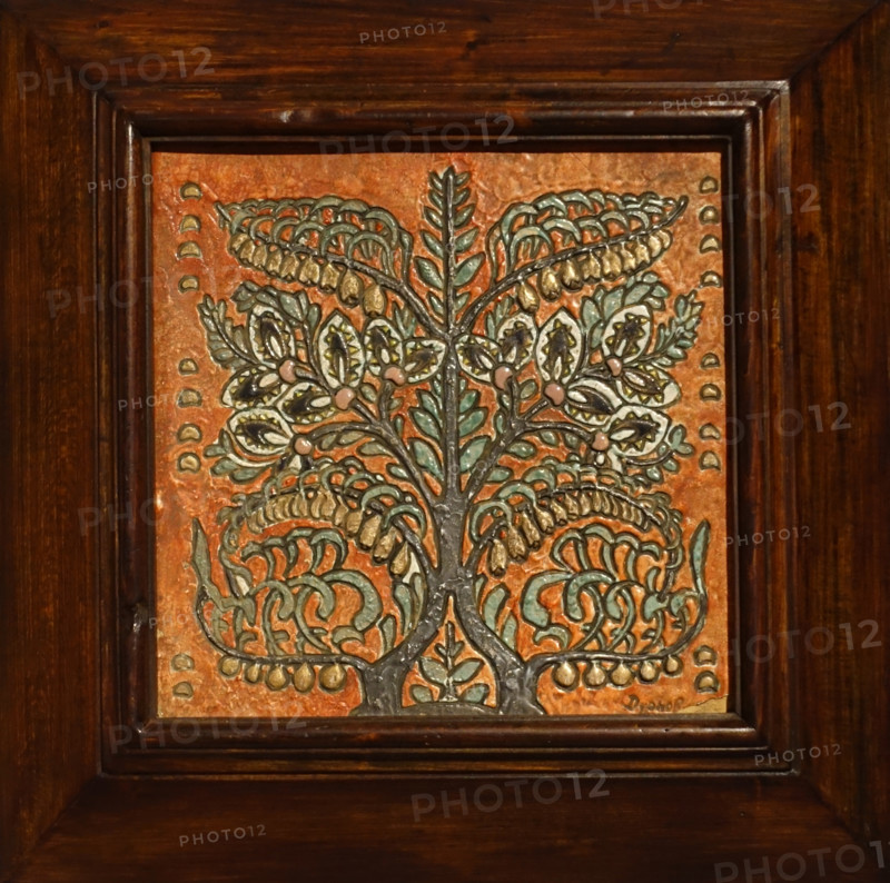 Tile in a wooden frame with a stylized image of a flowering bush.