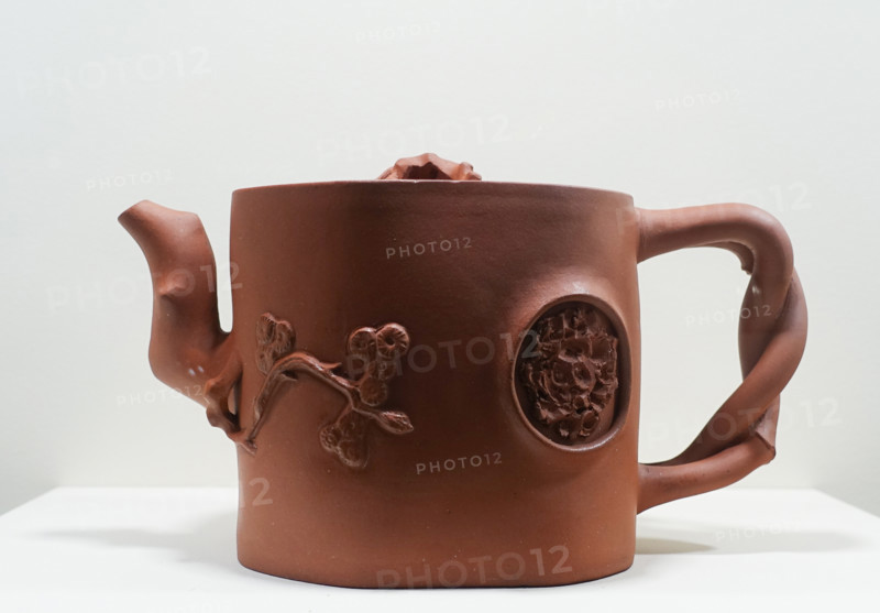 Teapot with an umbrella pine, a bat, and a blossoming mei plum branch on the lid.