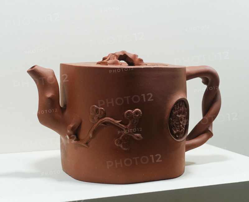 Teapot with an umbrella pine, a bat, and a blossoming mei plum branch on the lid.
