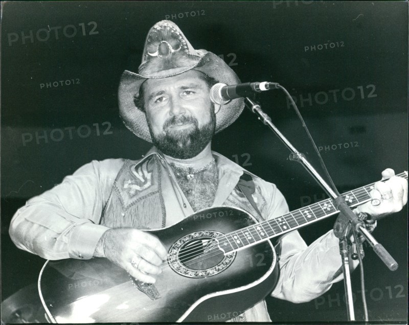 Johnny Lee playing guitar in concert