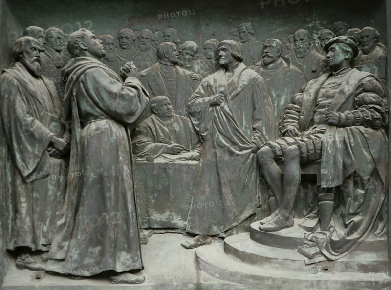 Diet of Worms. Assembly of the princes of the Holy Roman Empire held in Worms (Germany) from 28 January to 25 May 1521. It was presided over by Emperor Charles V of the Holy Roman Empire. Its purpose was to address the works of the reformer Martin Luther (1483-1546) for his criticism of the Church. Luther was summoned to recant his theses. Between 16 and 18 April, Luther spoke before the Diet, without renouncing his beliefs and vigorously defending his Protestant stance. He was accused of heresy, leading to his official break with the Church. Martin Luther responding before the Diet of Worms, 18 April 1521. Depicted, from left to right: Hieronymus Schurff (1481-1554), Martin Luther, Philip I, Landgrave of Hesse (1504-1567), Frederick III, Elector of Saxony (1463-1525), Johann Maier von Eck (1486-1543) and Emperor Charles V (1500-1558). Relief on the right side of the main entrance to Berlin Cathedral, created by German sculptor Gerhard Janensch (1860-1933), 1904. Germany.