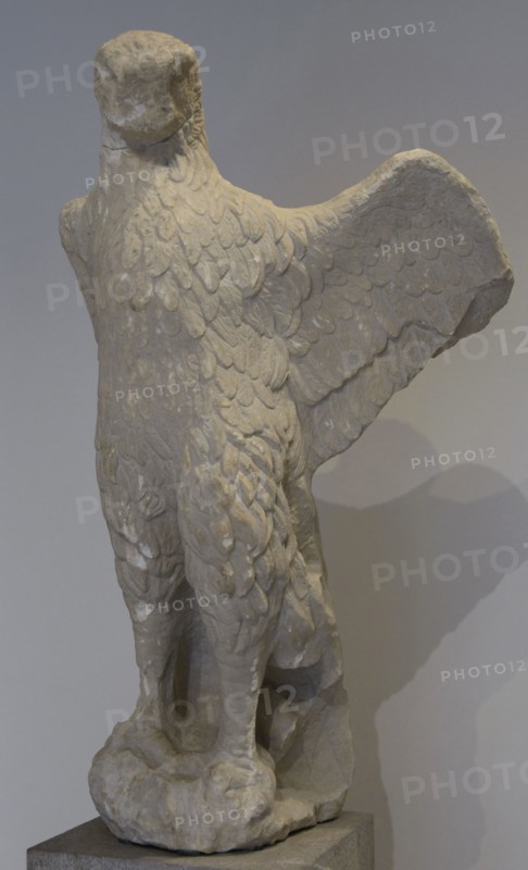 Eagle from a grave monument. The eagle turns its head towards a partially preserved snake that was raised threateningly and which it catches with its talons. The motif is a known omen, therefore the sculpture was probably found in the grave of a seer. Late 4th century BC. Archaeological Museum of Piraeus. Greece.