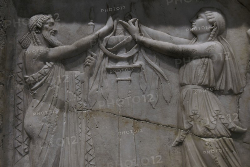 Ancient Greece. Priest and priestess in a ritual attitude. Detail of a relief slab. Marble. Archaeological Museum of Piraeus. Greece.