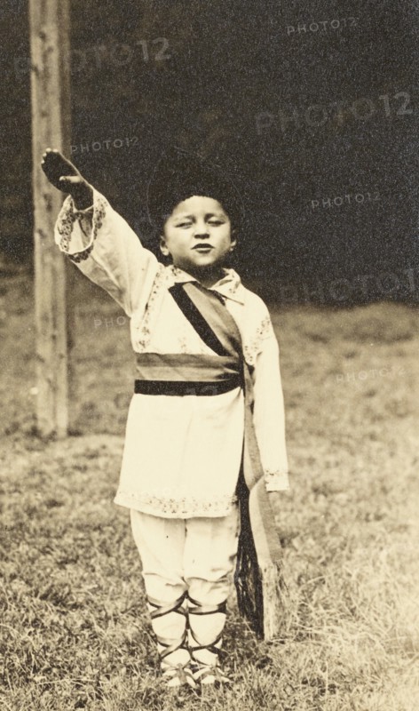 A child posing in traditional Romanian costume