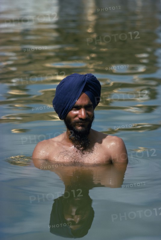 INDIA, Punjab, Amritsar, Hari Mandir or Golden Temple. Ritual bather in the Pool of Immortality to attain spiritual purification.