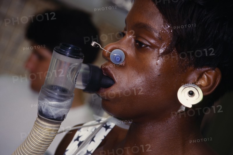 10001292 SPORT Gym Health VO2 MAX Endurance Testing with female athlete wearing breathing equipment and running on a treadmill with a coach at her side.