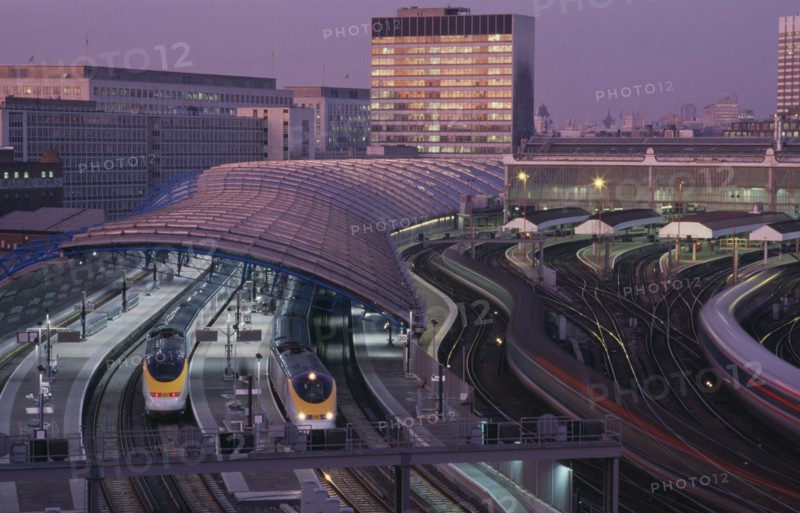 ENGLAND, London ,  Waterloo Station International Terminal with Eurostar trains in evening.  City buildings behind.