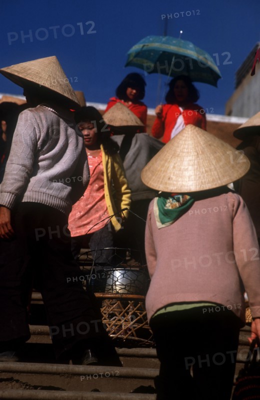 VIETNAM, Dalat, Women at Dalat market with wide straw hats and umbrella.