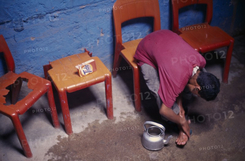 MOROCCO, General, Boy sitting on a chair washing his feet