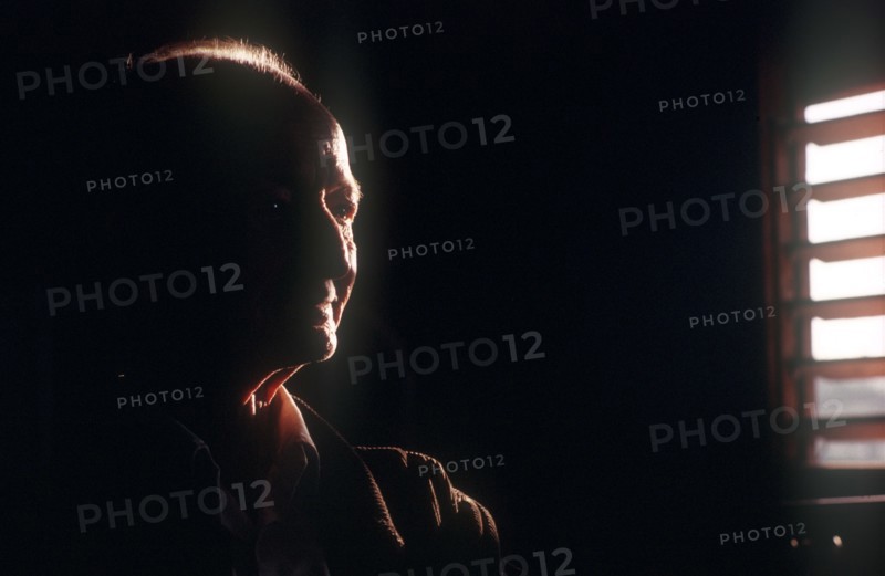CUBA, Pinar del Rio, Portrait of an elderly farmer seen in a dark room with half of his face visible by light from a nearby shuttered window