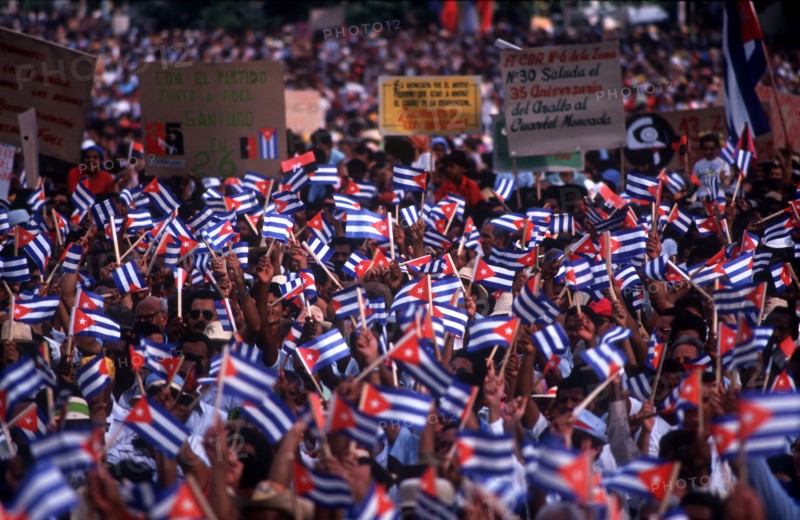 CUBA, Santiago, Crowds waving paper flags at the July 26th celebrations
