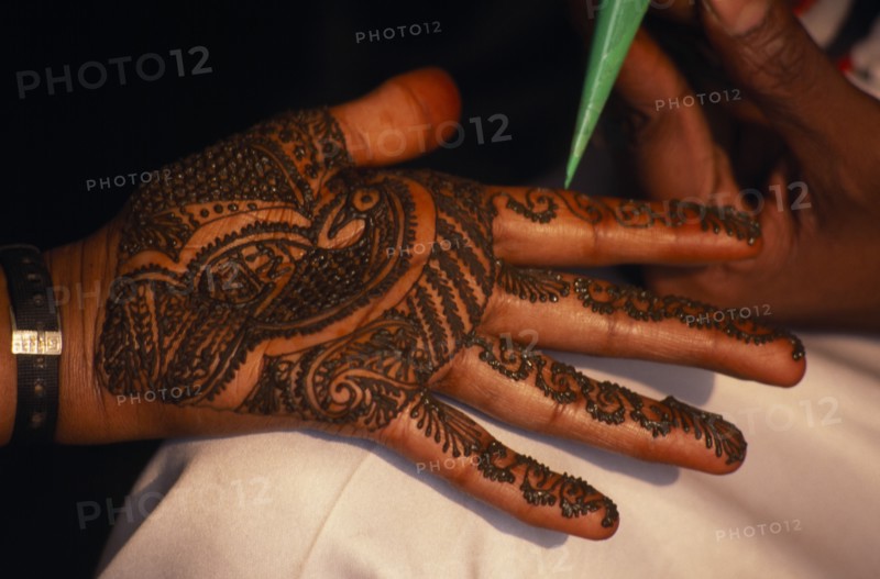 INDIA, Religion, Hindu, Hand of bride being decorated with henna paste for wedding.
