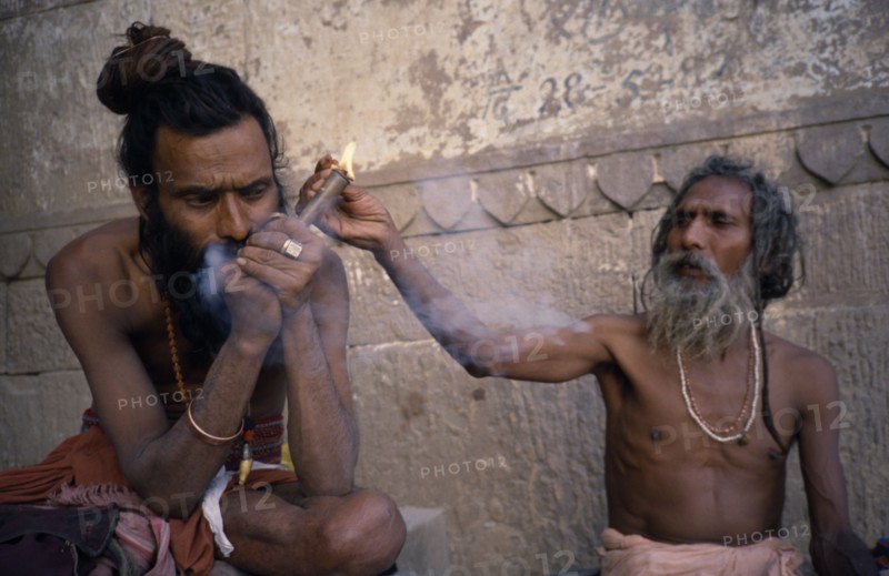 INDIA, Uttar Pradesh, Varanasi, Sadhus lighting and smoking chillum
