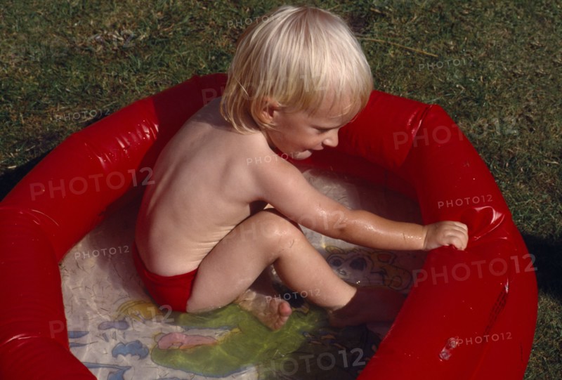 10017227 CHILDREN Leisure Swimming Young child playing in red padling pool