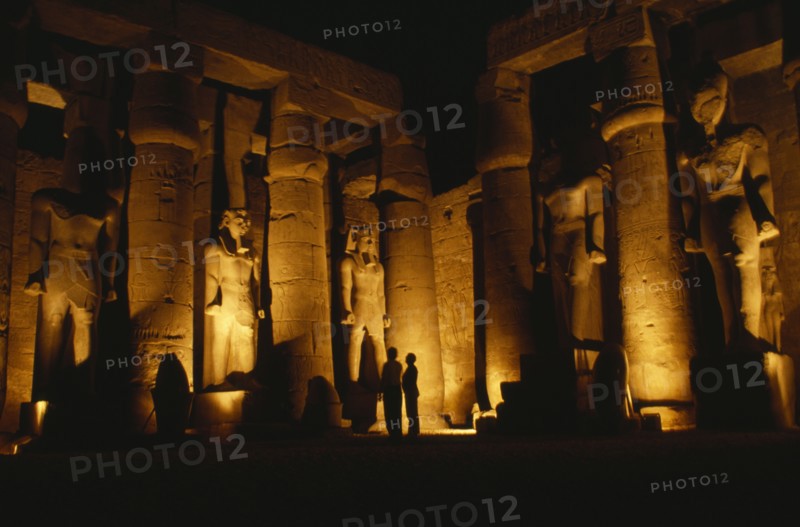 EGYPT, Luxor, The Temple illuminated at night with giant standing Statues of Rameses II