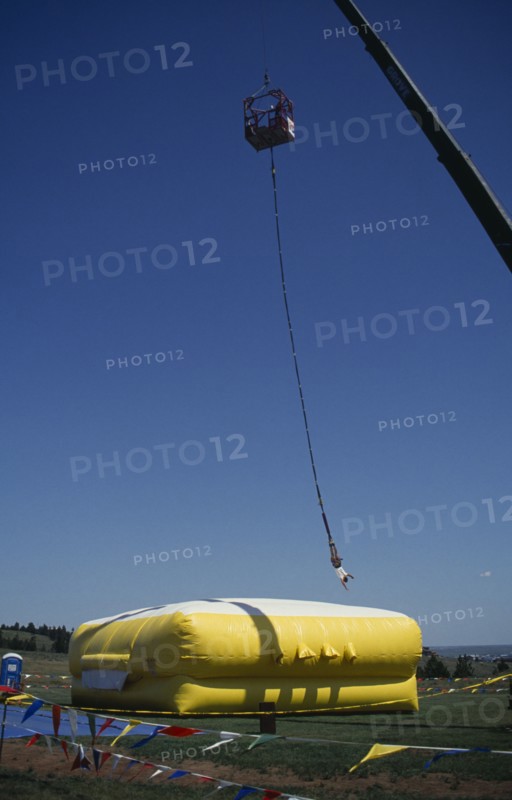 SPORT, Air, Bungee Jumping, Bungee jumper suspended from crane over inflated safety mat.