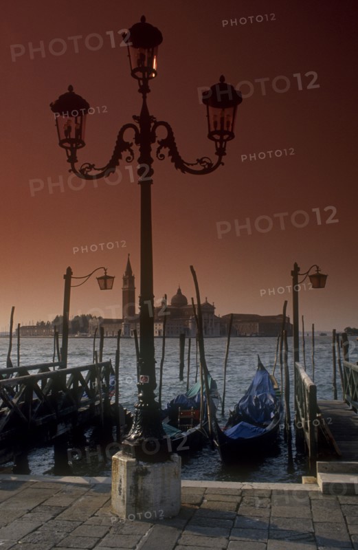 ITALY, Veneto, Venice, San Giorgio island behind moored gongolas and an ornate lampost