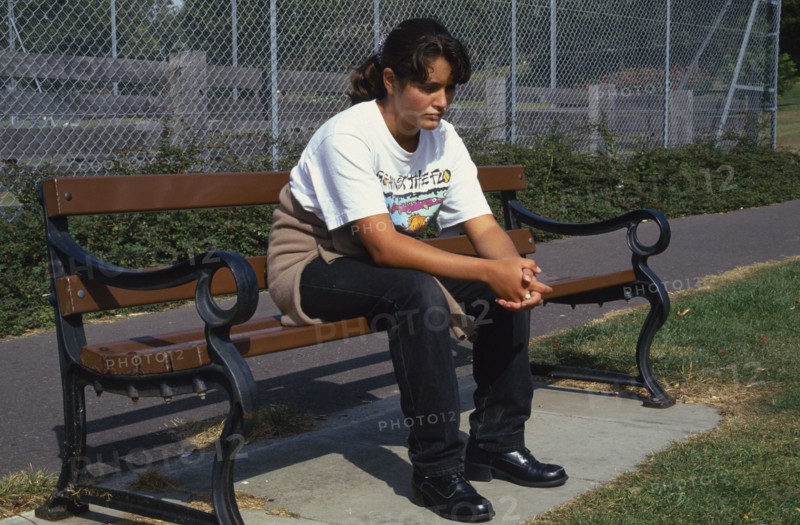 HEALTH, Moods, Teenager, Teenage girl on park bench looking sad and thoughtful.