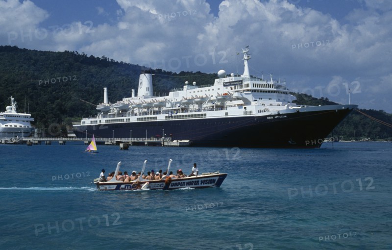WEST INDIES, Jamaica, Ocho Rios, Tourist boat full of passegers passing cruise ship moored in harbour.