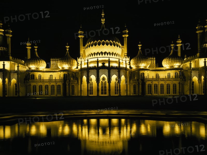 ENGLAND, East Sussex , Brighton, The Royal Pavilion illuminated at night with reflection in pond