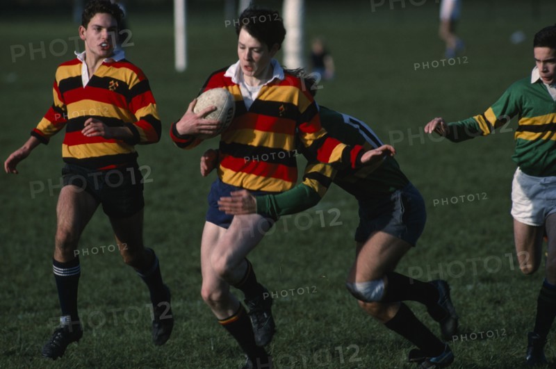 10045937 SPORT Ball Games Rugby Junior boys team  player being tackled by the opposition.