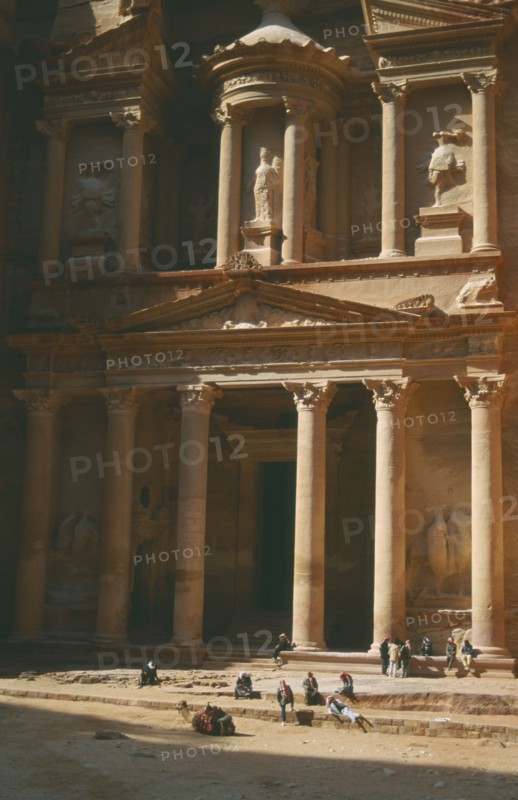 JORDAN, Petra, The Treasury with porticoed entrance carved into rock with camel and people in front
