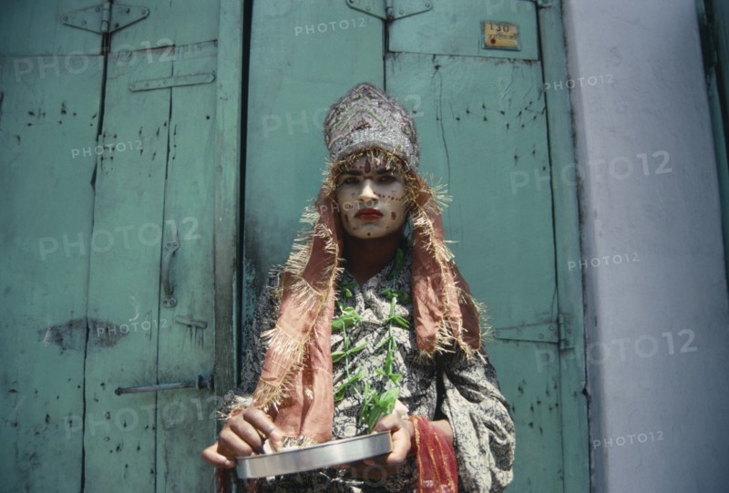 INDIA, Rajasthan, Udaipur , "Hermaphrodite with painted face and head-dress.  Ambiguous male features.  Subject of Indian myth, referred to as Hijras and often work as street performers."