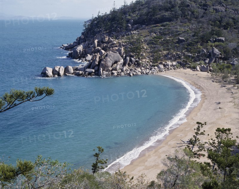 AUSTRALIA, Queensland, Magnetic Island, Arthur's Bay looking down onto  deserted beach with rocks at the far end