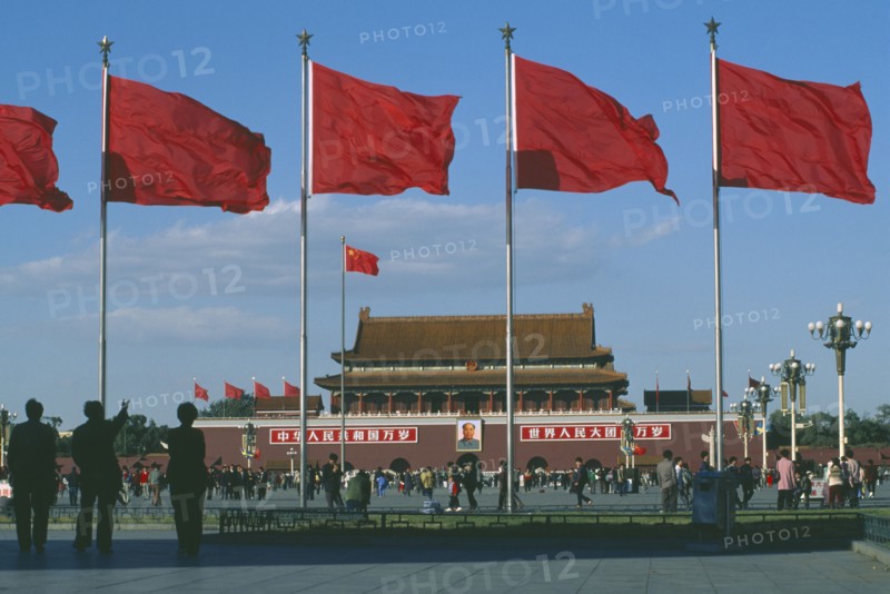 CHINA, Hebei, Beijing , Gate of Heavenly Peace entrance to the Forbidden City in Tiananmen Square behind red flags blowing in the wind
