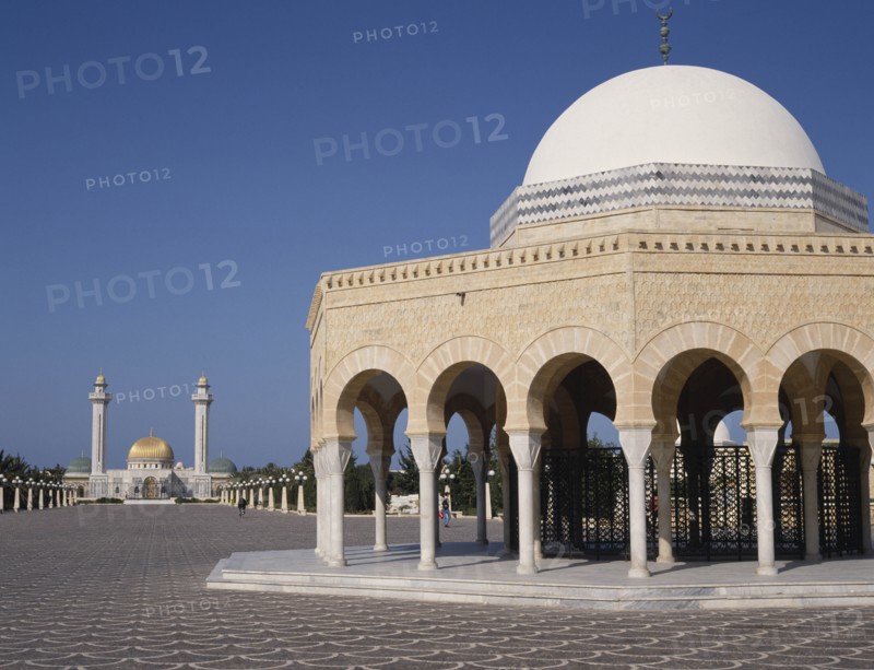 TUNISIA, Monastir, Bourguiba Mausoleum in distance beyond an arched portico with a white dome