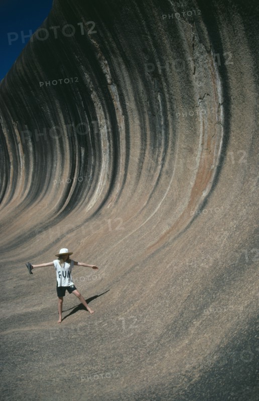 AUSTRALIA, Western Australia, Wave Rock, Tourist pretending to ride the waves like a surfer
