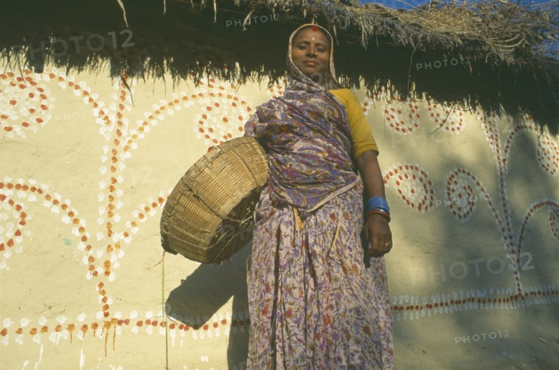 NEPAL, Madhya Pradesh, Janakpur , Mithila woman standing in front of painted house.
