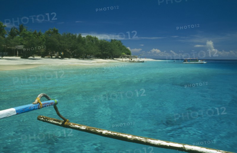 INDONESIA, Lombok, Gili Islands, Gili Trawangan beach seen from approaching outrigger canoe in clear water